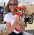 Jenny from Makko’s Snack holding a happy dog enjoying a natural birthday cake in San Antonio, Texas