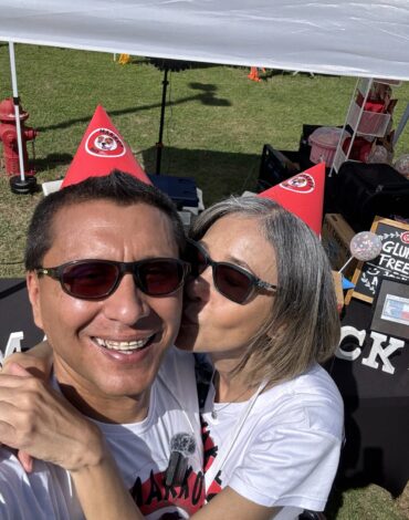 Makko’s Snack owners smiling and wearing red party hats at a pet festival in San Antonio, Texas
